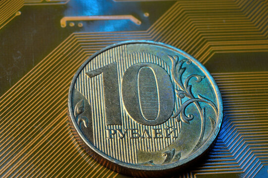 A coin with a face value of 10 rubles lies on a microcircuit. close-up. Translation of the inscription on the coin: "10 rubles" The concept of the digital economy in the Russian Federation