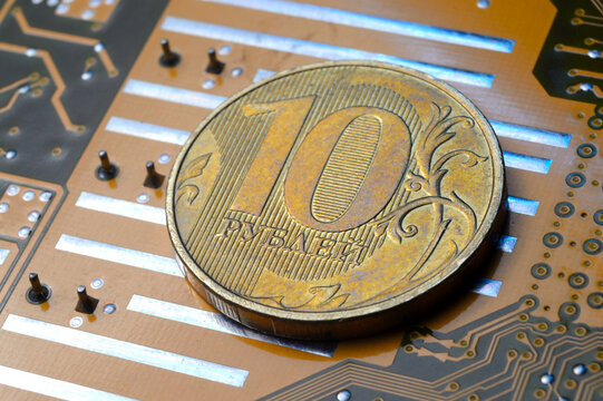 A coin with a face value of 10 rubles lies on a microcircuit. close-up. Translation of the inscription on the coin: "10 rubles" The concept of the digital economy in the Russian Federation