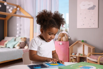 African American girl reading book at home