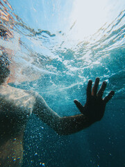 Underwater shot of male person swimming in sea water