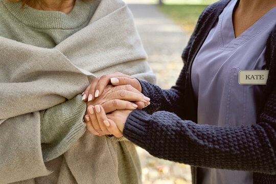 Caretaker holding hands consoling senior woman