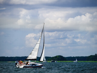 Sailboat sailing on a lake in a windy sunny summer day