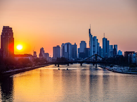 Germany, Hesse, Frankfurt, River Main canal at sunset with bridge and downtown skyscrapers in background