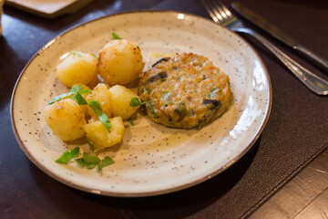 chicken burger with boiled potatoes on plate