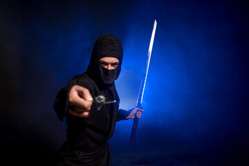 Medieval warrior ninja assassin throws shuriken in smoke