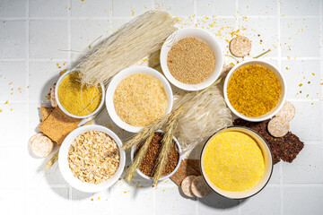 Selection of whole grains gluten free cereals. Set of various non-gluten cereals: rice, buckwheat, corn groats, quinoa, millet, oats, buckwheat, bulgur, porridge, barley, white background copy space