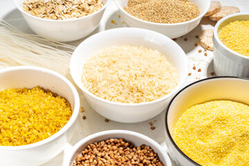 Selection of whole grains gluten free cereals. Set of various non-gluten cereals: rice, buckwheat, corn groats, quinoa, millet, oats, buckwheat, bulgur, porridge, barley, white background copy space