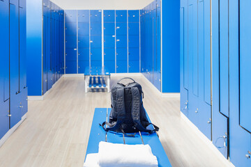 Backpack on bench in empty locker room at gym