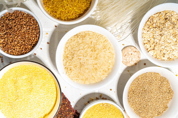 Selection of whole grains gluten free cereals. Set of various non-gluten cereals: rice, buckwheat, corn groats, quinoa, millet, oats, buckwheat, bulgur, porridge, barley, white background copy space