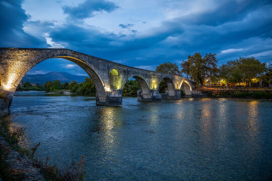 Illuminated Bridge of Arta on Arachthos river at night in Greece