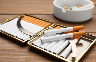 Stylish case with cigarettes on wooden table, closeup