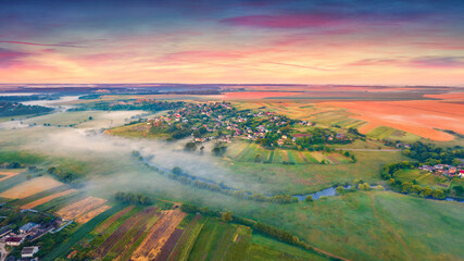 Spectacular sunrise on Ukrainian countryside with foggy fields. Attractive summer scene of outskirts of Ternopil town with small river, Ukraine, Europe. Traveling concept background.
