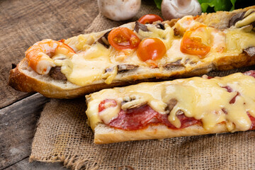 Two sandwich pizzas on a baguette, close-up. Italian sandwich, casserole