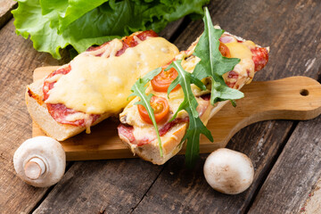 Sandwich pizza on a baguette, pizza on a baguette with cheese, sausages and arugula
