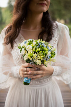 Smiling bride holding flower bouquet