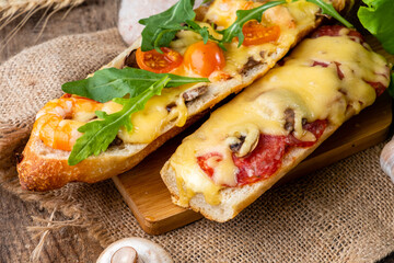Appetizing homemade pizza cooked on a baguette, homemade pastries, pizza sandwich close-up. - obrazy, fototapety, plakaty