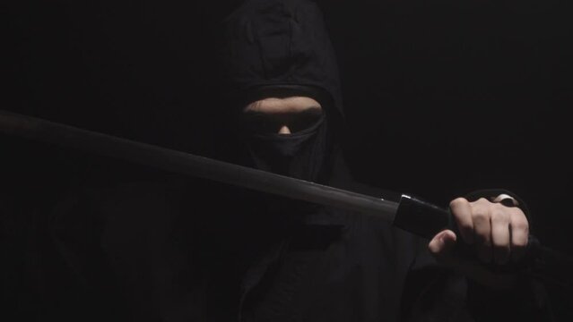 Medieval warrior assassin ninja with sword in aggressive pose in smoke