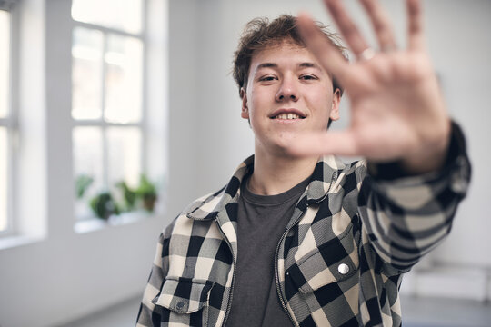 Smiling young man raising hand
