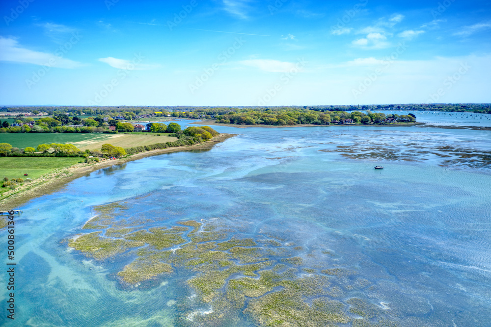 Wall mural Aerial photo over the estuary that leads into the small hamlet of Bosham Hoe in Chichester Harbour near Itchenor in West Sussex. - Wall murals