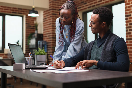 Research company office workers reviewing accounting documentation and looking for business solutions. Project manager instructing intern for startup project promoting campaign strategy.