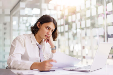 Business concept, Businessman reading financial report and analyze to make project on laptop