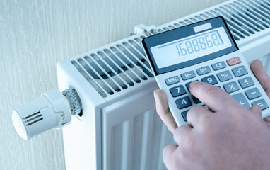 concept of expensive heating costs. hands with calculator consider cost of heating. saving energy...