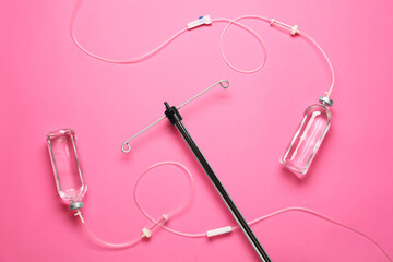 IV infusion set on pink background, flat lay