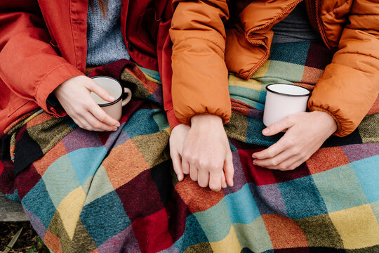 Couple with coffee cups holding hands
