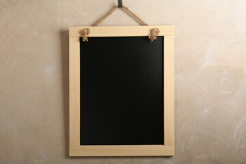 Clean small black chalkboard hanging on beige wall