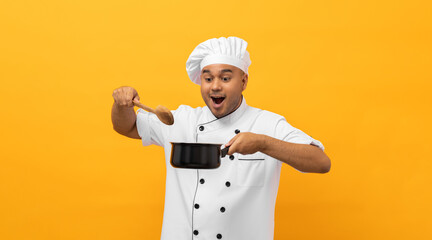 Young asian man chef in uniform holding soup pot utensils cooking in the kitchen various gesture action on isolated yellow background. Indian man Occupation chef restaurant and hotel.