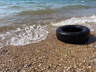 Car tire and pollution on beach