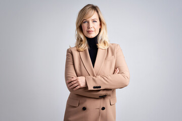 Studio portrait of attractive blond haired woman while standing at isolated background