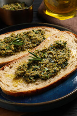 Tasty bruschettas with pesto and rosemary on plate, closeup