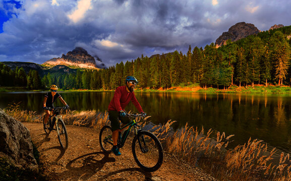 Cycling outdoor adventure in Dolomites. Cycling woman and man on electric mountain bikes in Dolomites landscape. Couple cycling MTB enduro trail track. Outdoor sport activity. © Gorilla