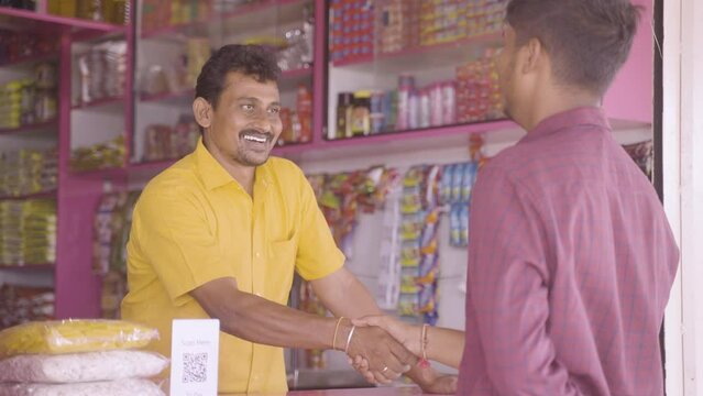 Handheld Shot Of Kirana Or Grocery Merchant Greeting Customer At Retail Store - Concept Of Successful Business, Communication, Conversation.