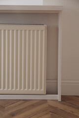 Modern panel radiator on white wall indoors