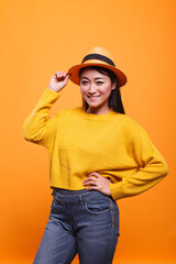 Cheerful charming woman smiling wide with confidence while wearing colorful vivid sweatshirt. Portrait of happy joyful positive asian woman laughing heartily while wearing yellow clothing.