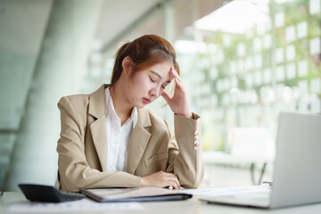 Burnout Syndrome. Portrait of Asian Business Woman feels uncomfortable working. Which is caused by stress, accumulated from unsuccessful work And less resting body. Consult a specialist psychiatrist.