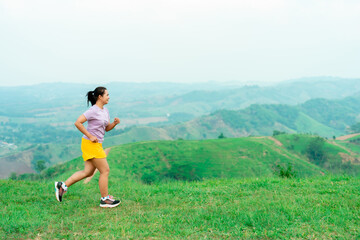 Asian trail runners, women  wearing sportswear are practicing on a high mountain running. During the evening when the air is fresh atmosphere is good.