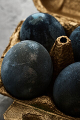 gray eggs lie in a golden box on a concrete