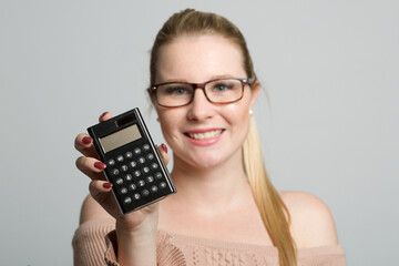 young smiling woman with glasses is presenting a calculator