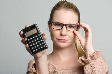 young woman with glasses is presenting a calculator