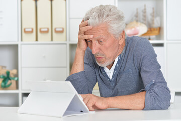 Fototapeta premium senior man with tablet computer at home