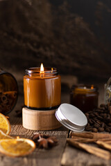 A set of different aroma candles in brown glass jars. Scented handmade candle. Soy candles are burning in a jar. Aromatherapy and relax in spa and home.
