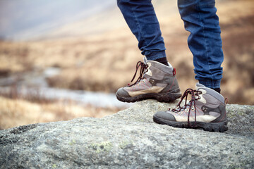 Hiker hiking over rocks on a mountain trail