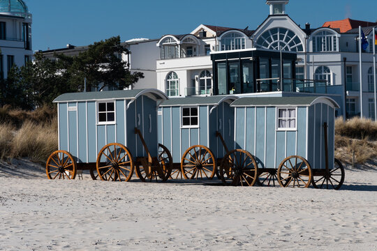 Blick vom Strand auf die Promenade von Binz auf R&uuml;gen. Auf dem Strand stehen Wagons, Strandwagen, die als Umkleide dienen