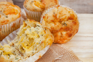 cheese and herb savory muffins baked to cheesy perfection on a rustic surface