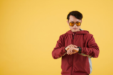 Serious young man in yellow sunglasses checking fitness tracker app of notification on smartwatch