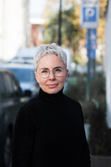 Portrait of a mature woman with grey hair and eyeglasses. Casual look.