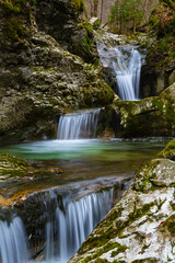 Beautiful soft cascades of fresh mountain stream in autumn forest